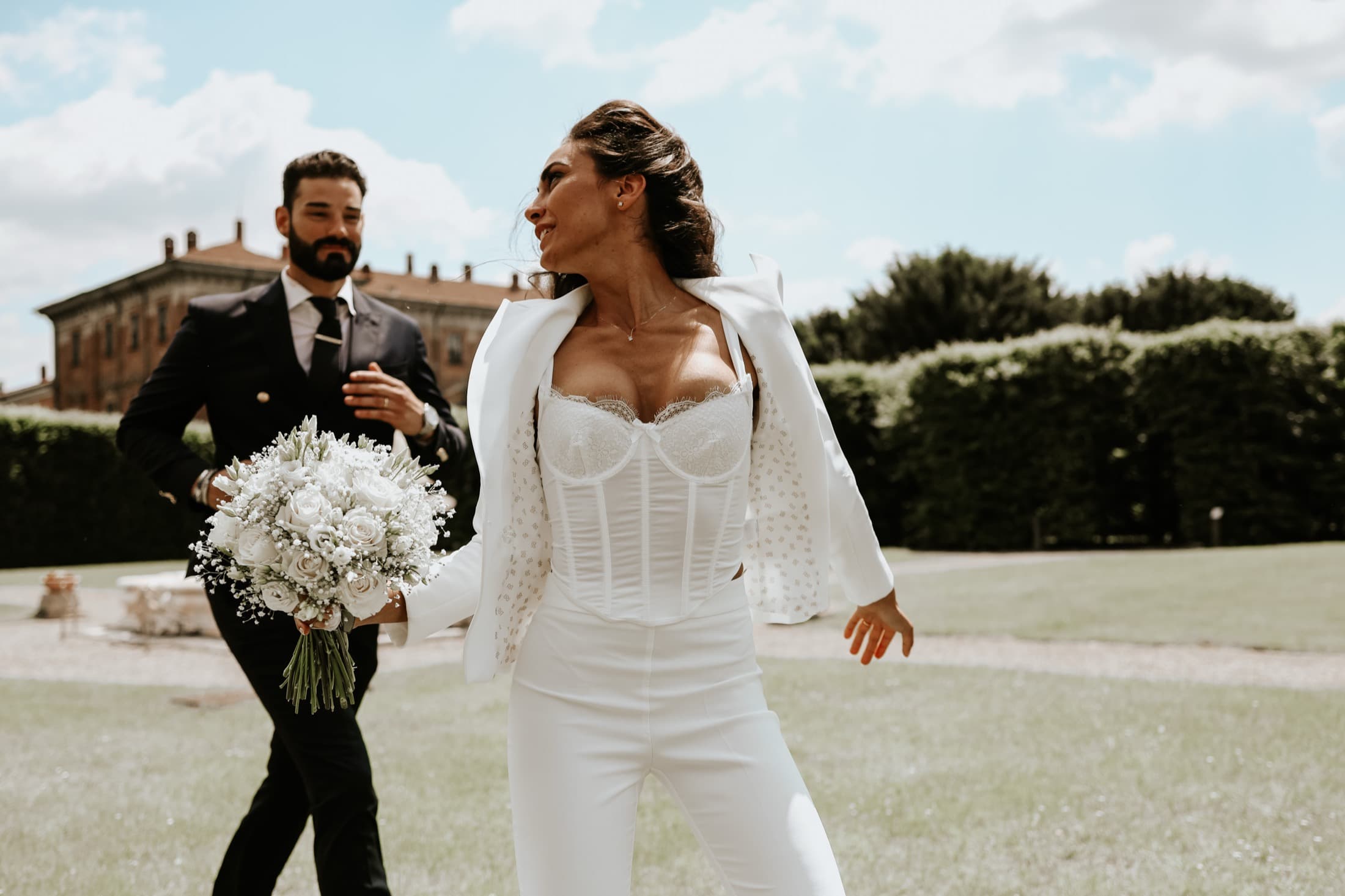 Bride walking across the lawn with her bouquet