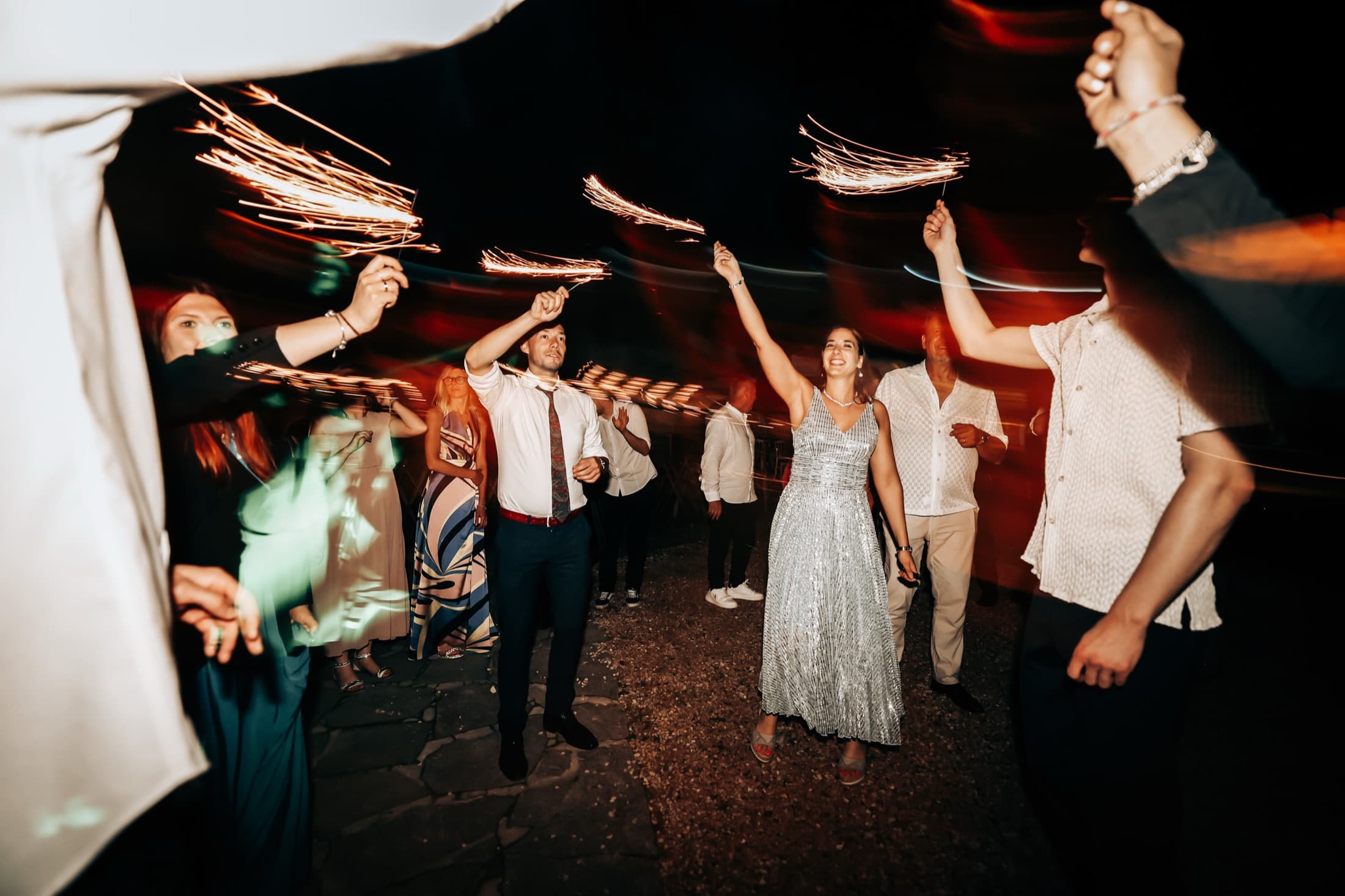 Guests cheering with sparklers at the reception
